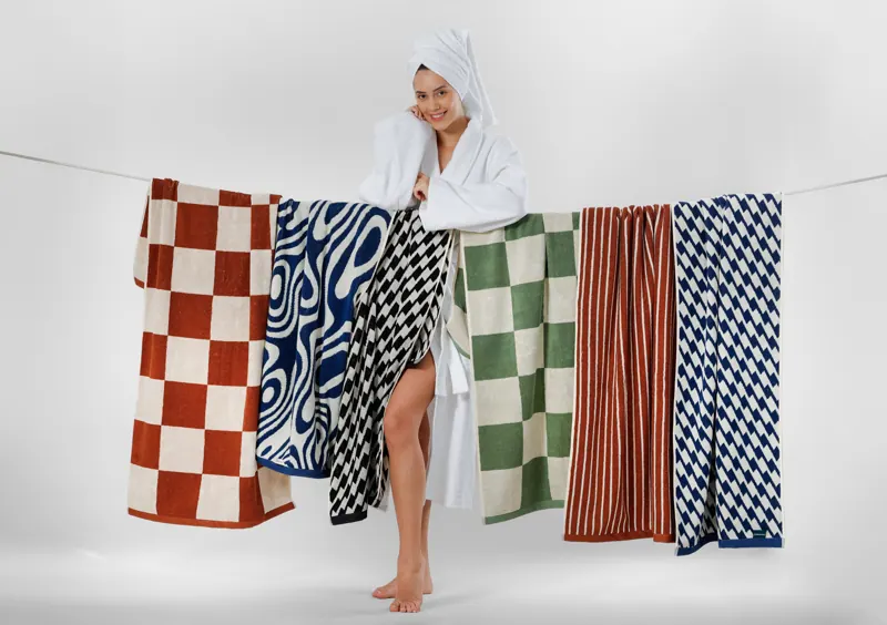 Model beside jacquard towels hung on a line